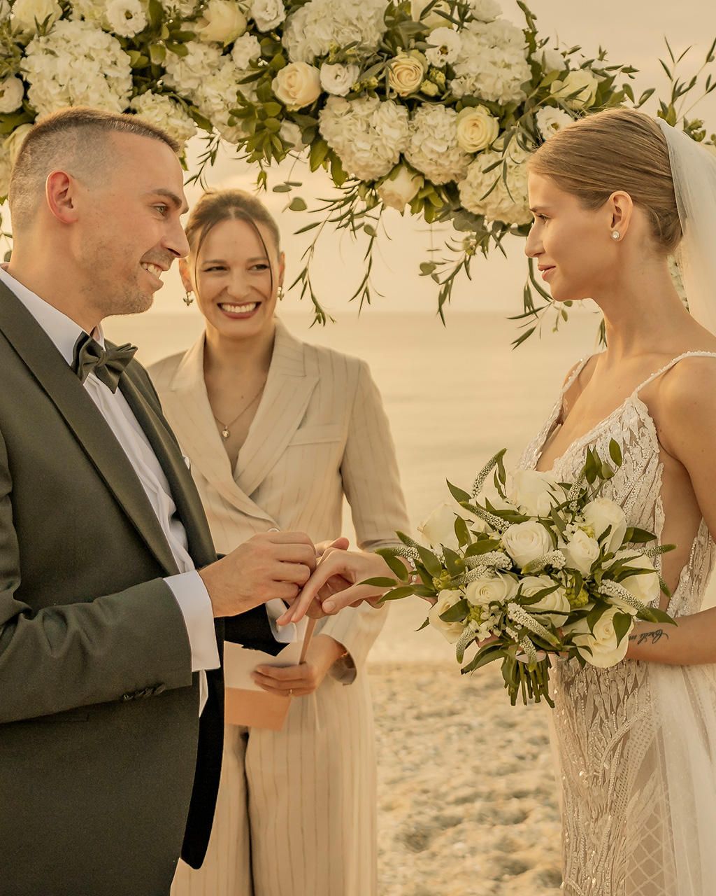 The groom puts a ring on the bride
